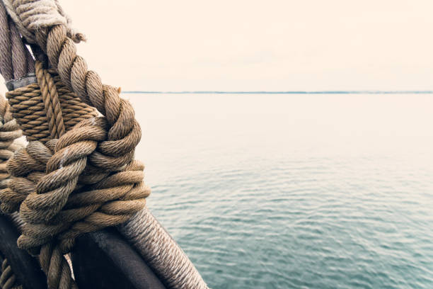 nautical knot of rope in front of the sea - boat deck rope nautical vessel old imagens e fotografias de stock