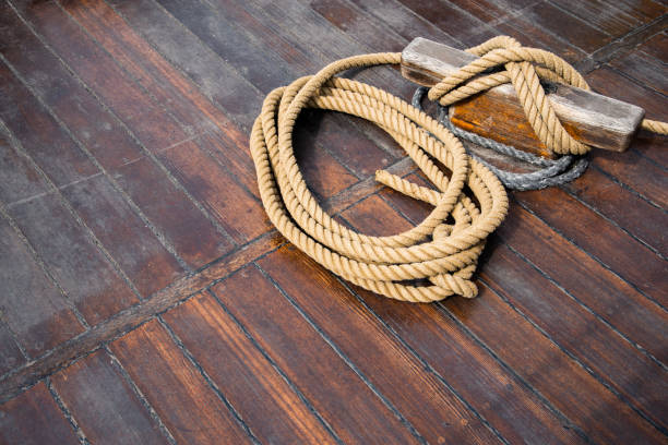 Jakarta, Java, Indonesia: manual work is used to load cargo into a pinisi schooner tall ship at Sunda Kelapa harbor - bags are carried on the shoulders of works over a fragile gangplank - old port on the Ciliwung River estuary, once the main port of Sunda Kingdom of Pajajaran and a Portuguese outpost.