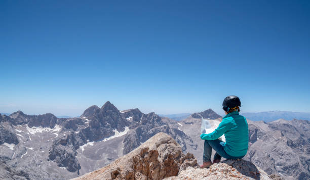 l'alpiniste féminin regarde la carte dans le sommet d'une montagne - atlas mountains photos et images de collection