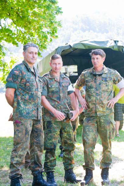 три армейских офицера наблюдают за военными учениями - вооружённые силы германии стоковые фото и изображения
