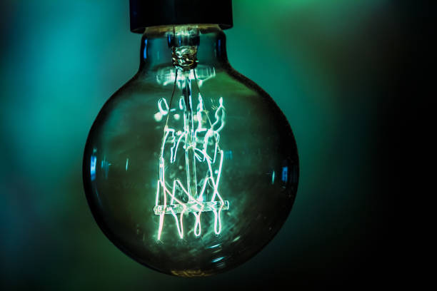 istock Retro bulb emitting green light in green space 1165936405
