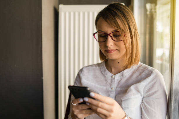 istock Young woman using smart mobile phone at the cafe checking messages sending waiting for response 1165937843