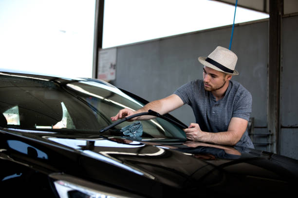 istock Young man washing his car in car wash 1165939084