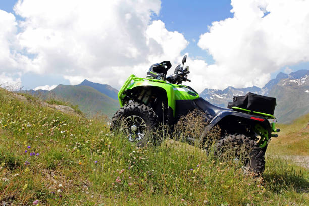 istock With the ATV in the mountains. A green ATV stands on a steep mountain path. 1165940659