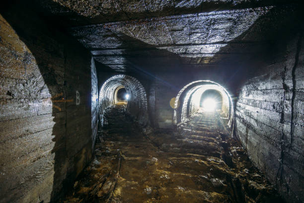 istock Dark dirty abandoned uranium mine with rusty remnants of railway 1165946373