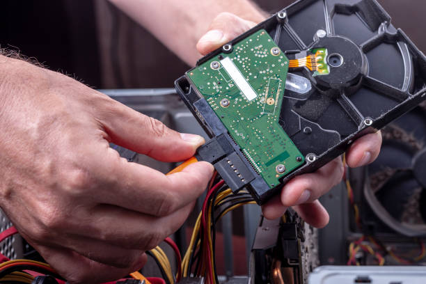 istock person holds dusty hdd from desktop for cleaning or upgrade old broken hardware. hard drive sata and power connection interface close up.upgrade desktop hardware. 1165950359