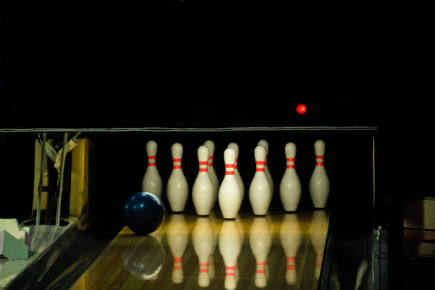 istock Blue ball rolling on a bowling alley lane with pins 1165950393