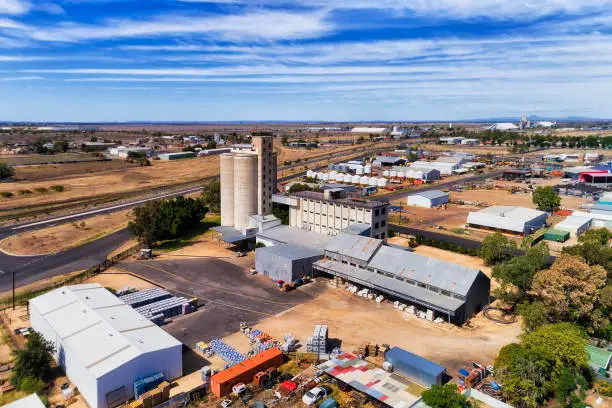 Grain  elevator in MOree agricultural town of australian artesian basin on grain belt - supply chain processing yard with storage warehouses and farm equipment.