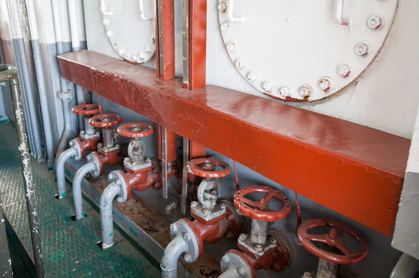 istock Pipe system with large red valves and metal armour 1165957734