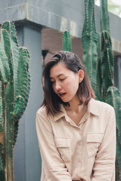 istock A woman sitting with a cactus 1165963295