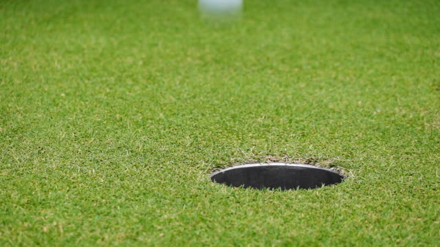 Slow Motion Golf Ball Falls Into The Hole Close Up