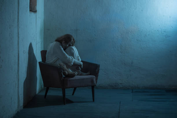 girl in white dress on old armchair in basement stock photo