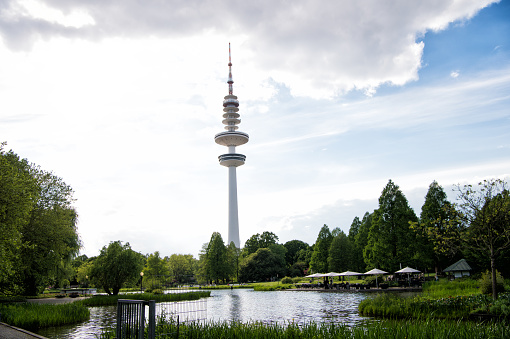 Sending and receiving waves. Tower or radio mast. TV tower on urban landscape. Tall tower supporting transmitting antenna. Tower structure for telecommunications and broadcasting