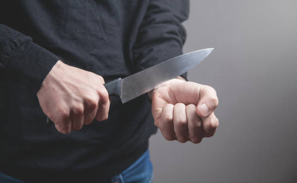 istock Man with a knife cutting veins. Suicide 1165983297