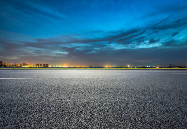 Empty road with panoramic cityscape at sunset stock photo