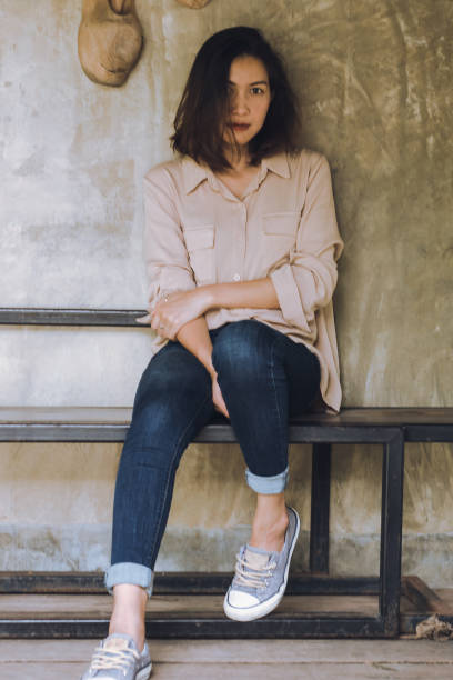 istock Women are sitting against the old wall. 1165984100