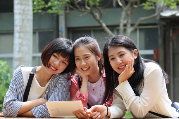 istock Young beautiful females checking tablet at public park 1165986820