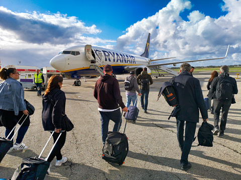 Luqa Airport, Malta - April 8 2019:  Ryanair passengers boarding a B737 airplane at Malta International Airport, Luqa. Ryanair is the largest low-cost European airline scheduled passenger carrier.  Several people have carry-on luggage,