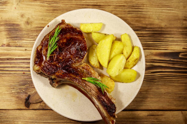 구운 감자와 허브를 나무 테이블에 구운 뼈에 구운 쇠고기 갈비 눈 스테이크 - sirloin steak baked potato beef gourmet 뉴스 사진 이미지