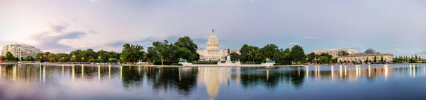 Panorama view of the United States Capitol building reflected on the reflection pool. Panorama view of the United States Capitol building reflected on the reflection pool when sunset at nation mall, Washington DC, USA. panoramic stock pictures, royalty-free photos & images