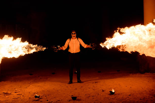istock Halloween man in costume with flamethrower in his hands. Devil makeup on face 1165996031