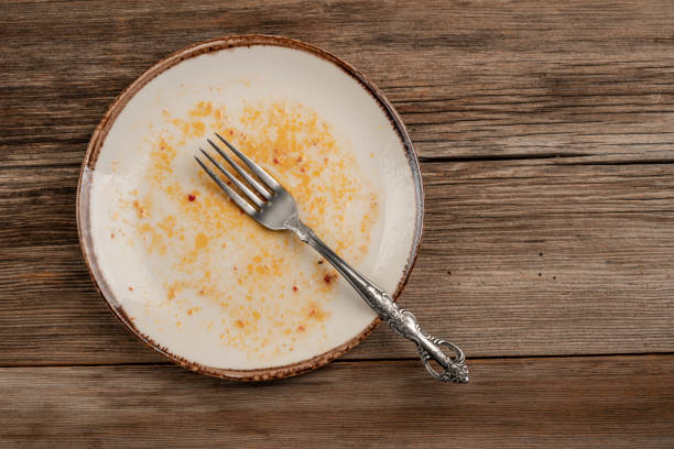 istock a dirty empty plate on wooden table after dinner 1166011679
