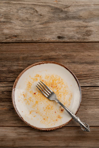 istock a dirty empty plate on wooden table after dinner 1166011734