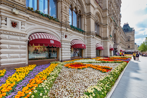 Moscow, Russia - July 28, 2019: Flowerbed against wall of GUM State Department Store in Moscow at sunny summer day. Traditional annual Flower Festival in GUM