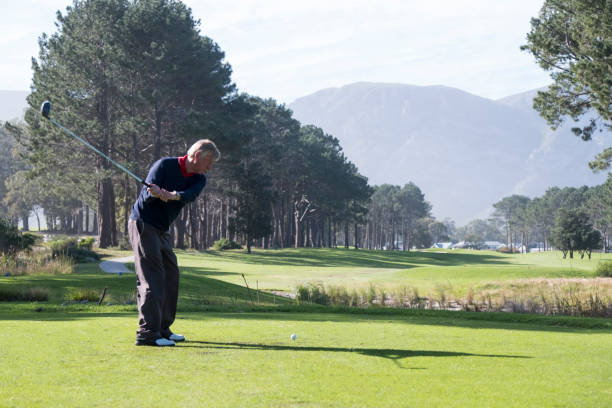 istock Elderly man hitting his driver off the T-box on the golf course 1166012812