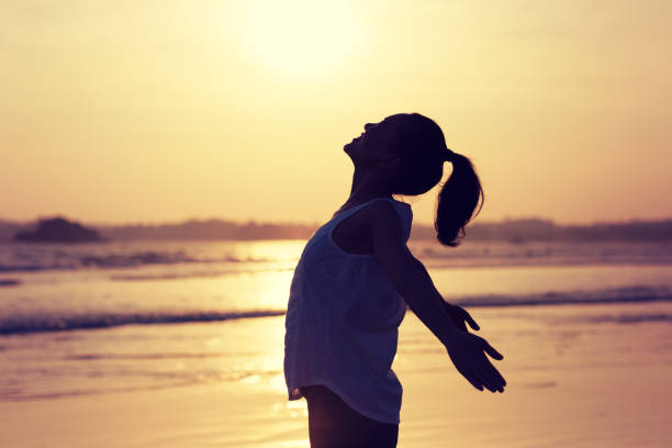 istock Woman enjoy the harmony on sunset beach 1166013004