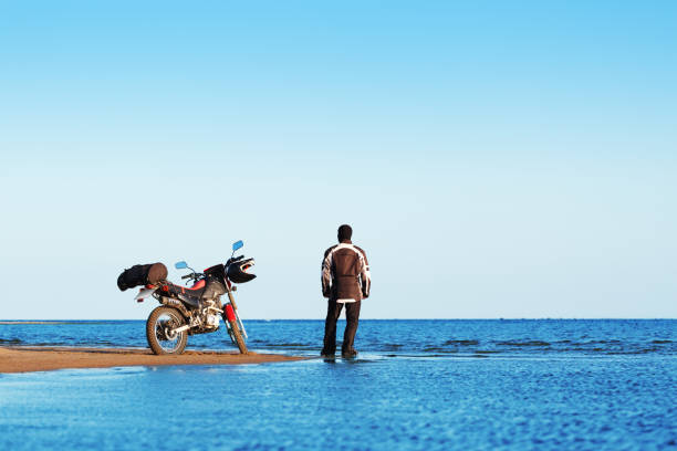istock Biker with a motorcycle on the beach. 1166013660