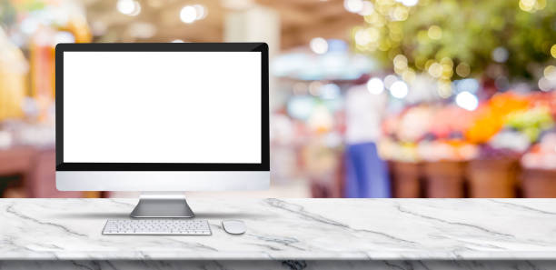 istock Blank screen desktop computer on marble table top with blur people shopping at supermarket bokeh background,Mock up for display or montage of design. 1166013739