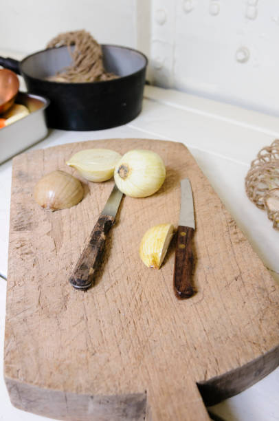 Onions being chopped on an old fashioned wooden chopping board