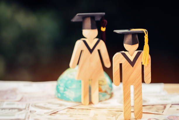 istock Education knowledge learning study abroad international Ideas. People Sign wood with Graduation celebrating cap on US dollar bill, America global map show alternative studying Back to School Concept 1166019322