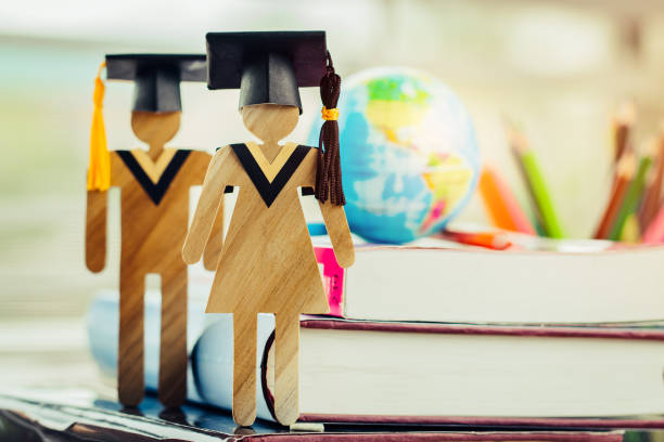 istock America Education knowledge learning study abroad international Ideas. People Sign wood with Graduation celebrating cap on open textbook with model global map, alternative studying world wide 1166020009