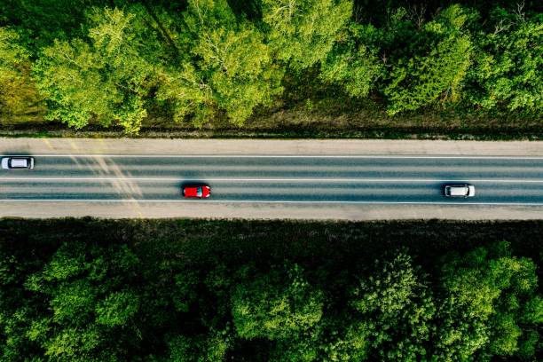 widok z lotu ptaka samochodów przejeżdża nych przez las na drodze krajowej. - straight road zdjęcia i obrazy z banku zdjęć