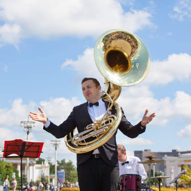 ニューライフブラスバンド、管楽器奏者、オーケストラが音楽を演奏し、スーザフォンを持つ男性ミュージシャン、ヘリコンと黒いスーツを着たトランペッター、夏の日vdnkh公園 - trumpet musical instrument jazz brass instrument ストックフォトと画像