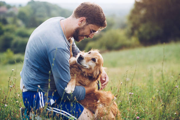 istock Guy and his dog, golden retriever, nature 1166024343