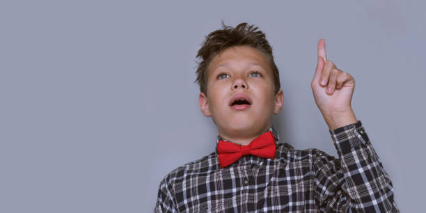 istock Young schoolchild pointing up portrait 1166025621