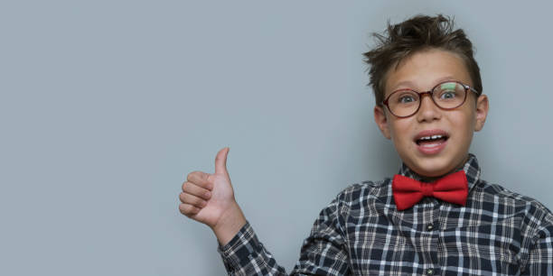istock Young boy giving thumbs up portrait on violet background 1166026240