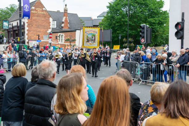 Durham Miner's Gala aka Big Meeting. Durham, UK - 13th July 2019: 135th Durham Miner's Gala aka Big Meeting. Held annually, large crowds gather to celebrate Miners history with marches and speeches by labour politicians, inlcuidng Jeremy Corbyn.
The Durham Miners' Gala is a large annual gathering and labour festival held on the second Saturday in July in the city of Durham, England. It is associated with the coal mining heritage (and particularly that of miners' trade unionism) of the Durham Coalfield, which stretched throughout the traditional County of Durham. It is also locally called "The Big Meeting" or "Durham Big Meeting".
Its highlight consists of a parade of banners, each typically accompanied by a brass band, which are marched to the old Racecourse, where political speeches are delivered. In the afternoon a Miners' service is held in Durham Cathedral, which may include the blessing of any new banners. labour movement workers union strike stock pictures, royalty-free photos & images