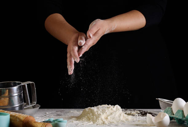 istock Chef hand clap and white flour on black background 1166029575