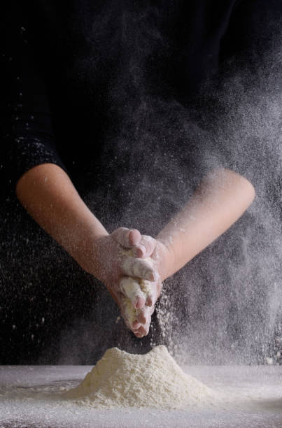 istock Chef hand clap and white flour on black background 1166029621