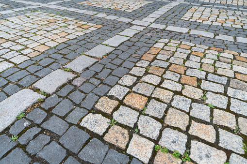 Old paving stones pattern. Texture of ancient german cobblestone in city downtown. Little granite tiles. Antique gray pavements.