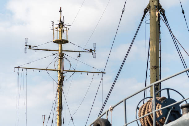ship mast of frigate, longboat or navy battleship. metal mast pole. ship awaits captain at docks. lowered sails, blue sky on background. - skeg imagens e fotografias de stock