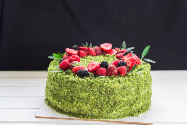 gâteau vert d'épinard avec la couronne des baies fraîches. gâteau vert, biscuit vert, fraise, framboise, tableau blanc - tea cake photos et images de collection