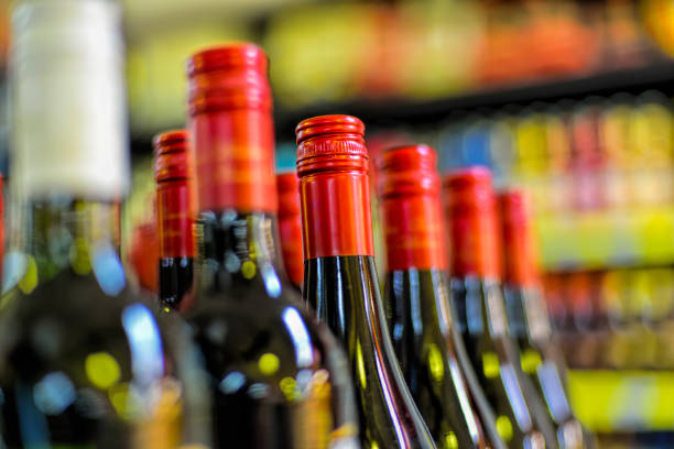 Bottle red wine on a old oak wooden table and coral orange background.