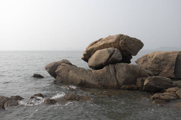 Rocks on a waterfront. Gray and hazy horizon. Western ocean view of South Korea.