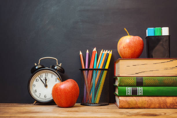 istock Books, pencils, apple on chalkboard background. Back to school concept. 1166035798