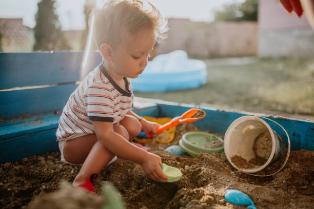 Child plays with his single mother in the sandbox Child plays with mother and enjoys his childhood sandbox stock pictures, royalty-free photos & images